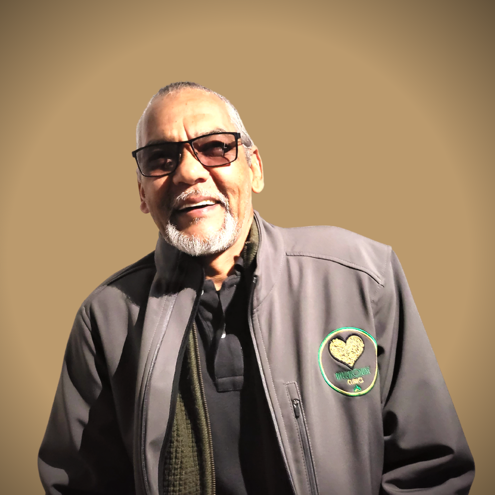 Een man met een bril en een jas met een hart erop