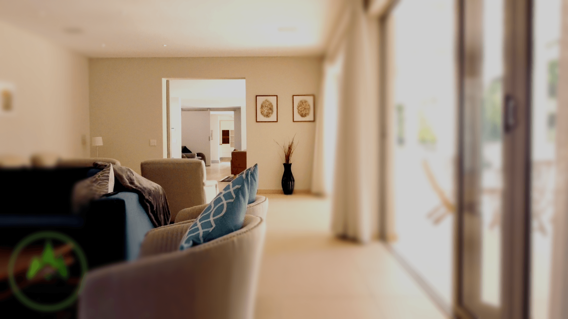 Een woonkamer met een bank, een stoel en glazen schuifdeuren.