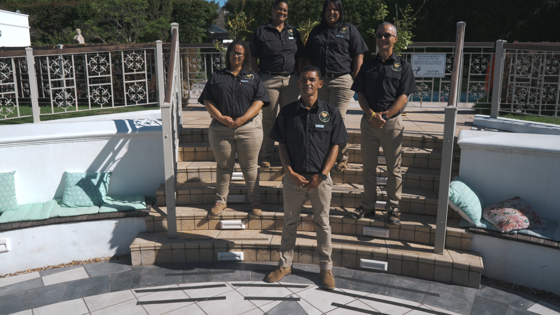 Een groep mensen poseert voor een foto voor een zwembad.