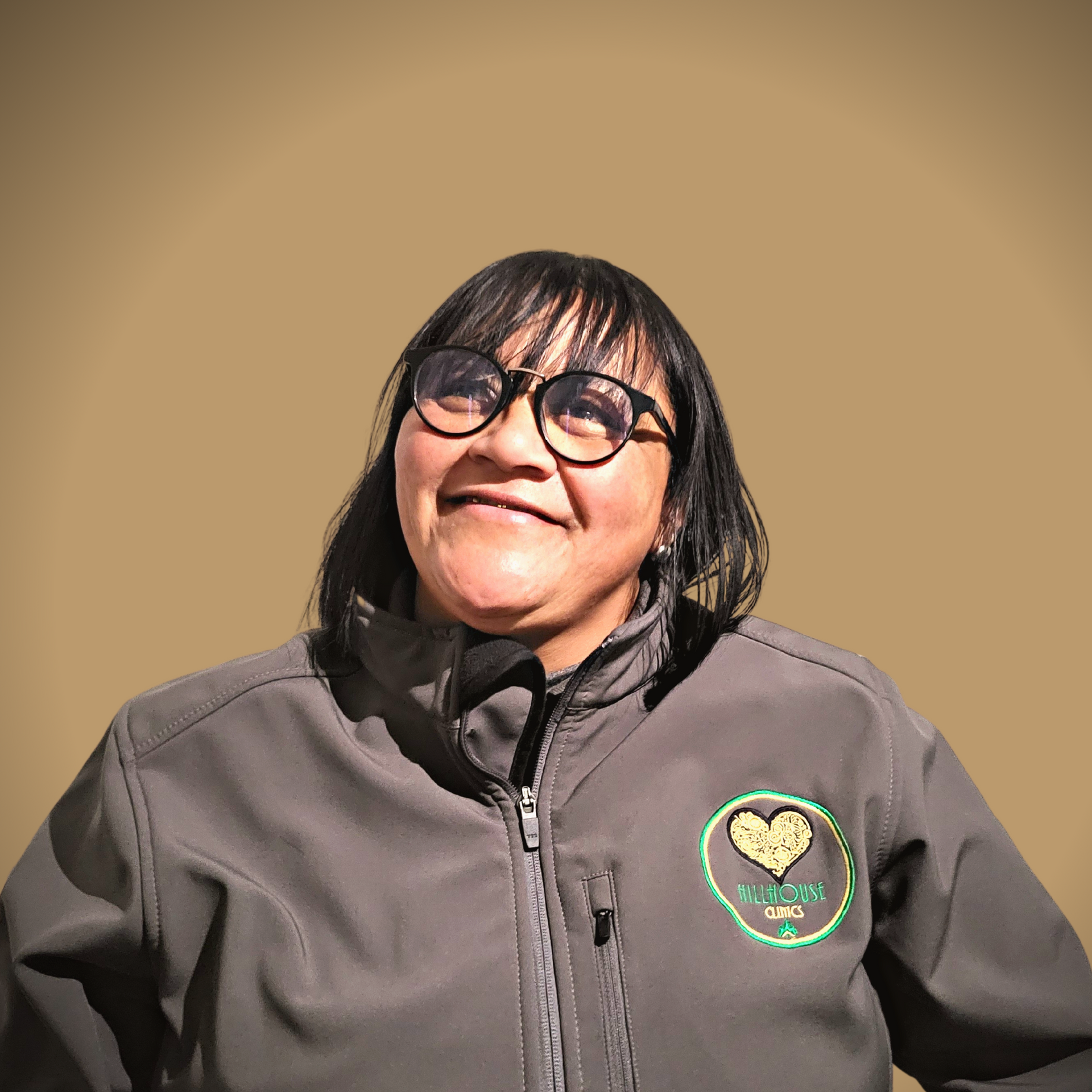 Een vrouw met een bril en een jas met een hart erop