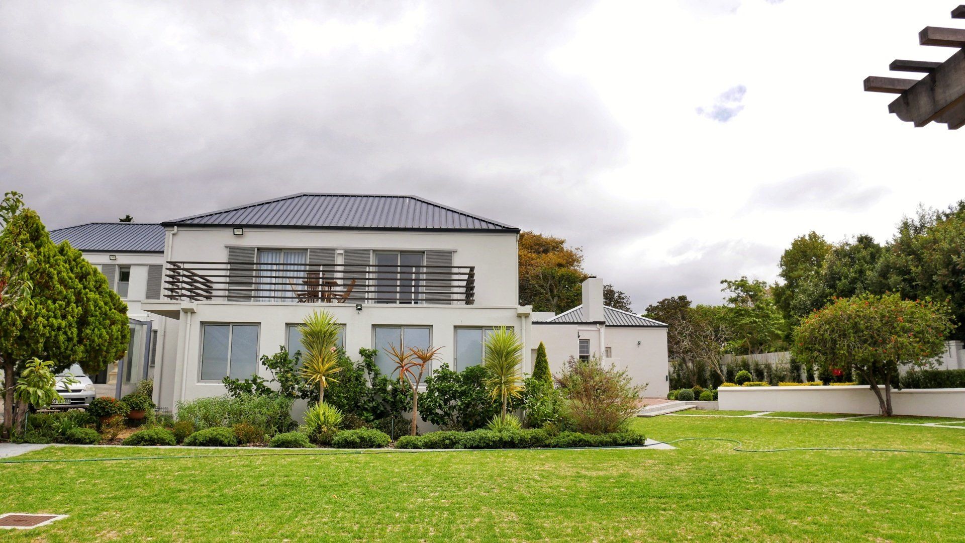 Een groot wit huis staat midden in een weelderig groen veld