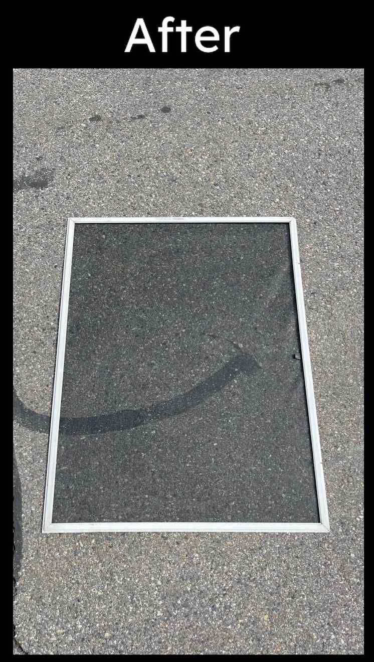 A picture of a screen door sitting on top of a concrete surface.