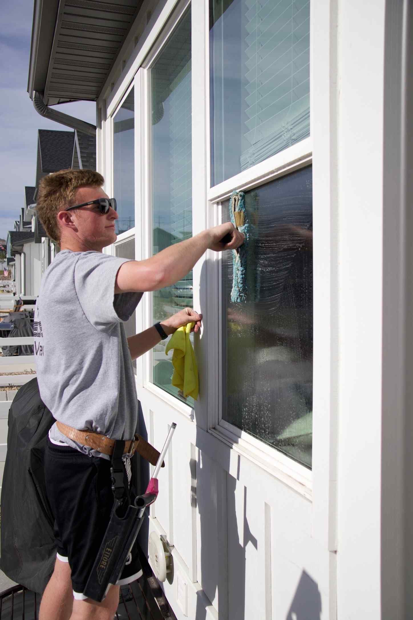 A man is cleaning a window with a brush.