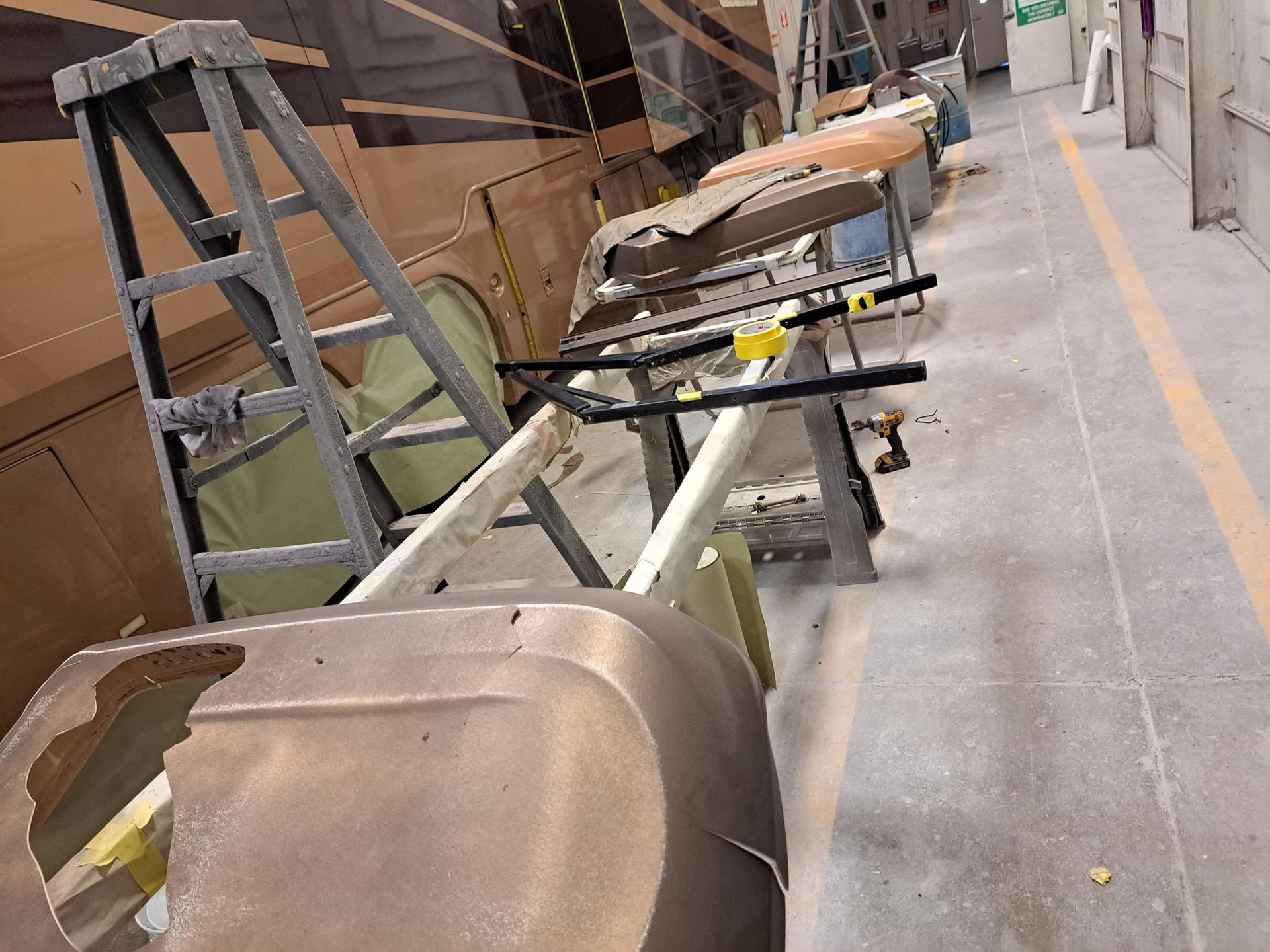 Workshop interior with boat parts in progress, work tables, ladder.