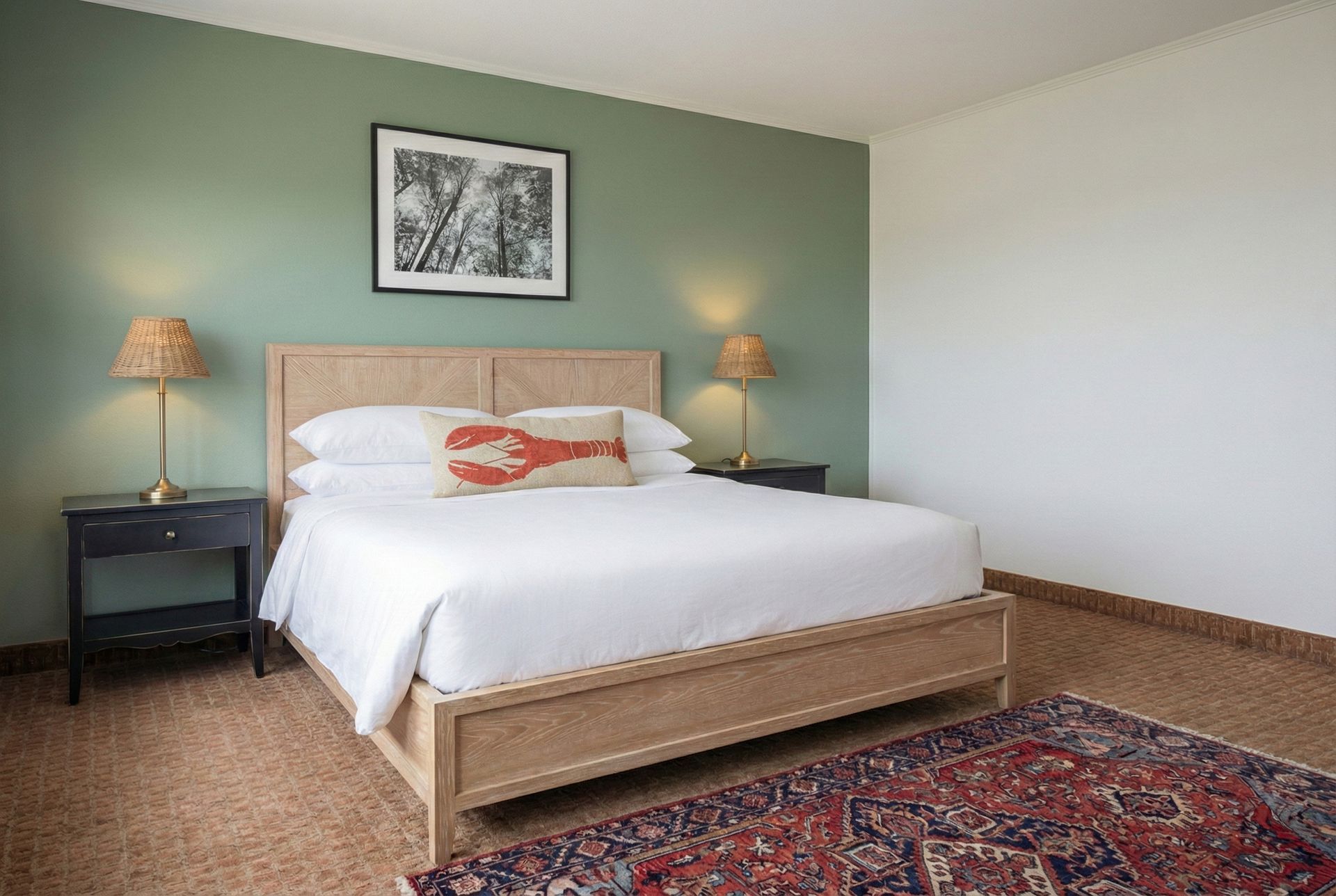 Bedroom with bed, nightstands, lamps, green wall, and framed artwork. Red rug on wood floor.