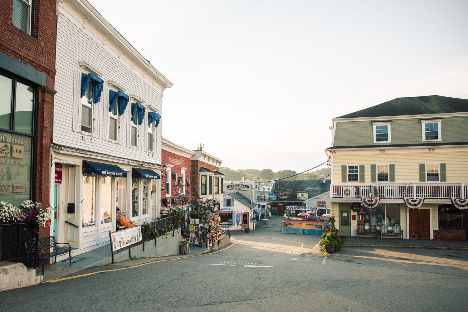 A quaint street scene lined with shops and buildings under a bright sky.