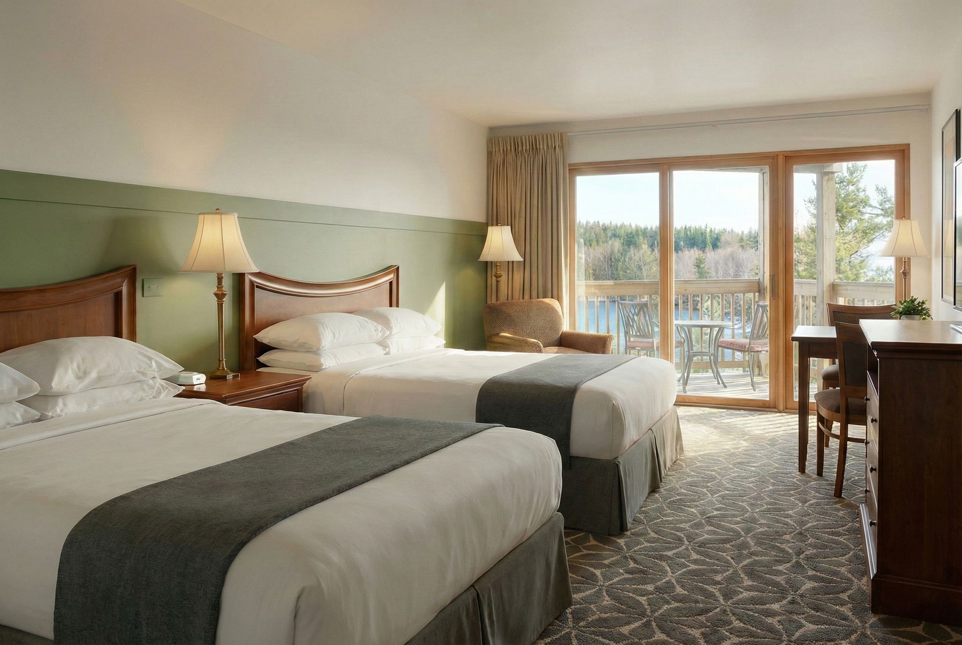 Hotel room with two beds, a desk, and a balcony with a view.