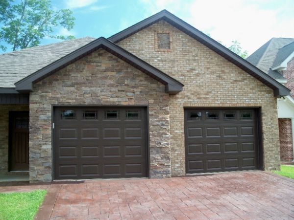 Brown brick garage with two dark brown garage doors.
