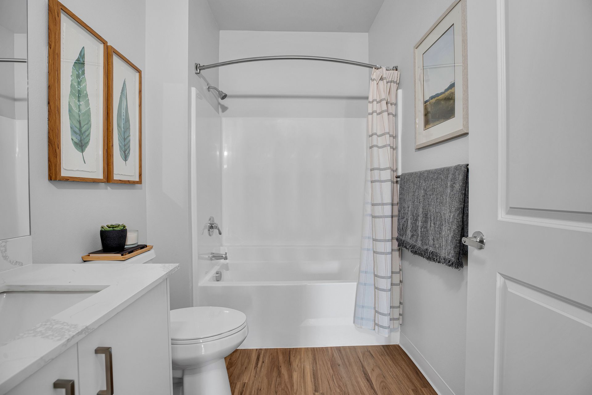 A bathroom with a toilet , sink , bathtub and shower curtain.