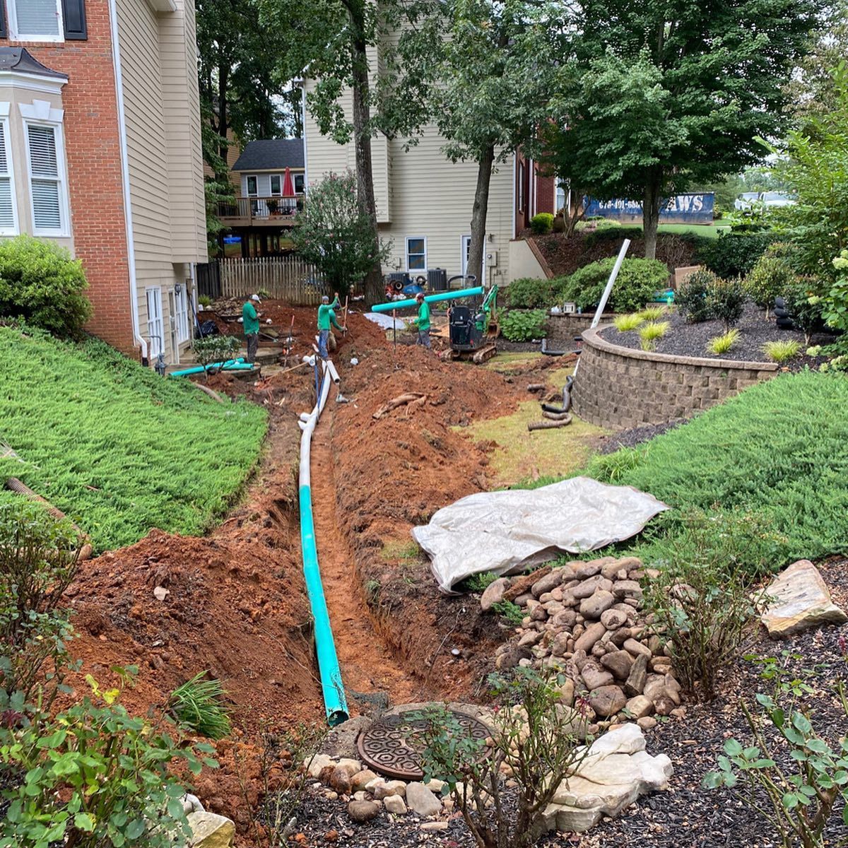A drainage system is being installed in the backyard of a house.
