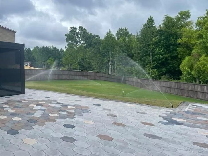 A sprinkler is spraying water on a lawn in a backyard.