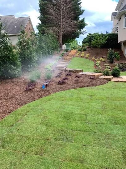 A sprinkler is spraying water on a lush green lawn.