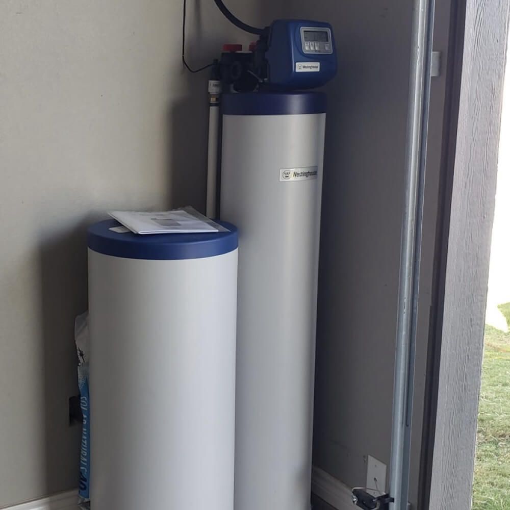 Two water tanks are sitting next to each other in a room.