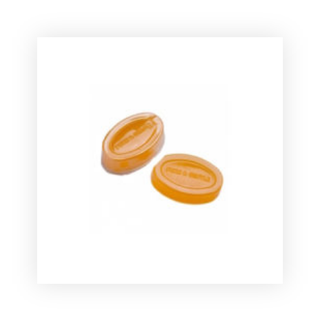 Two oval shaped pieces of soap on a white background