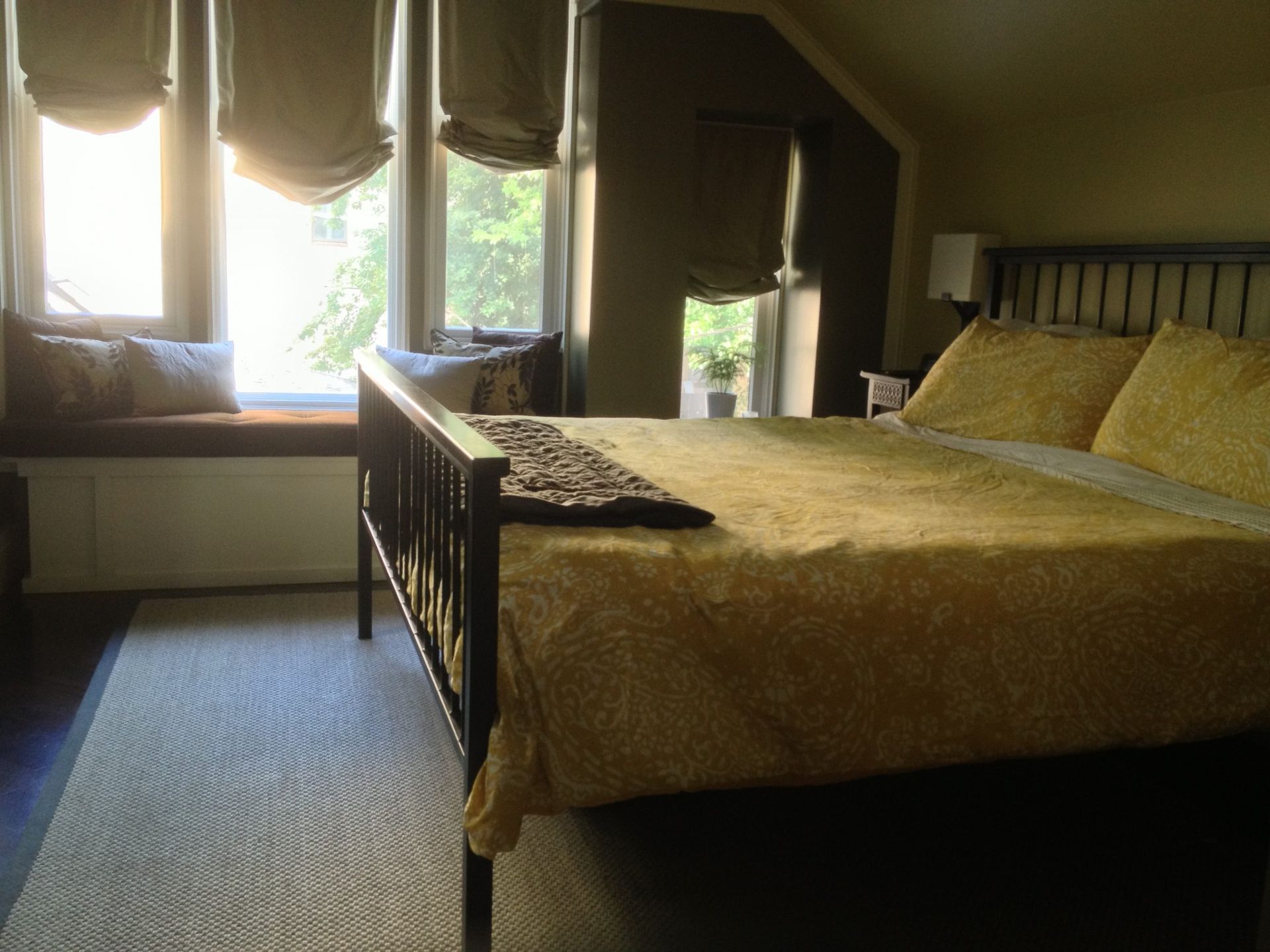 Cozy bedroom with a large bed, window seat, and soft daylight