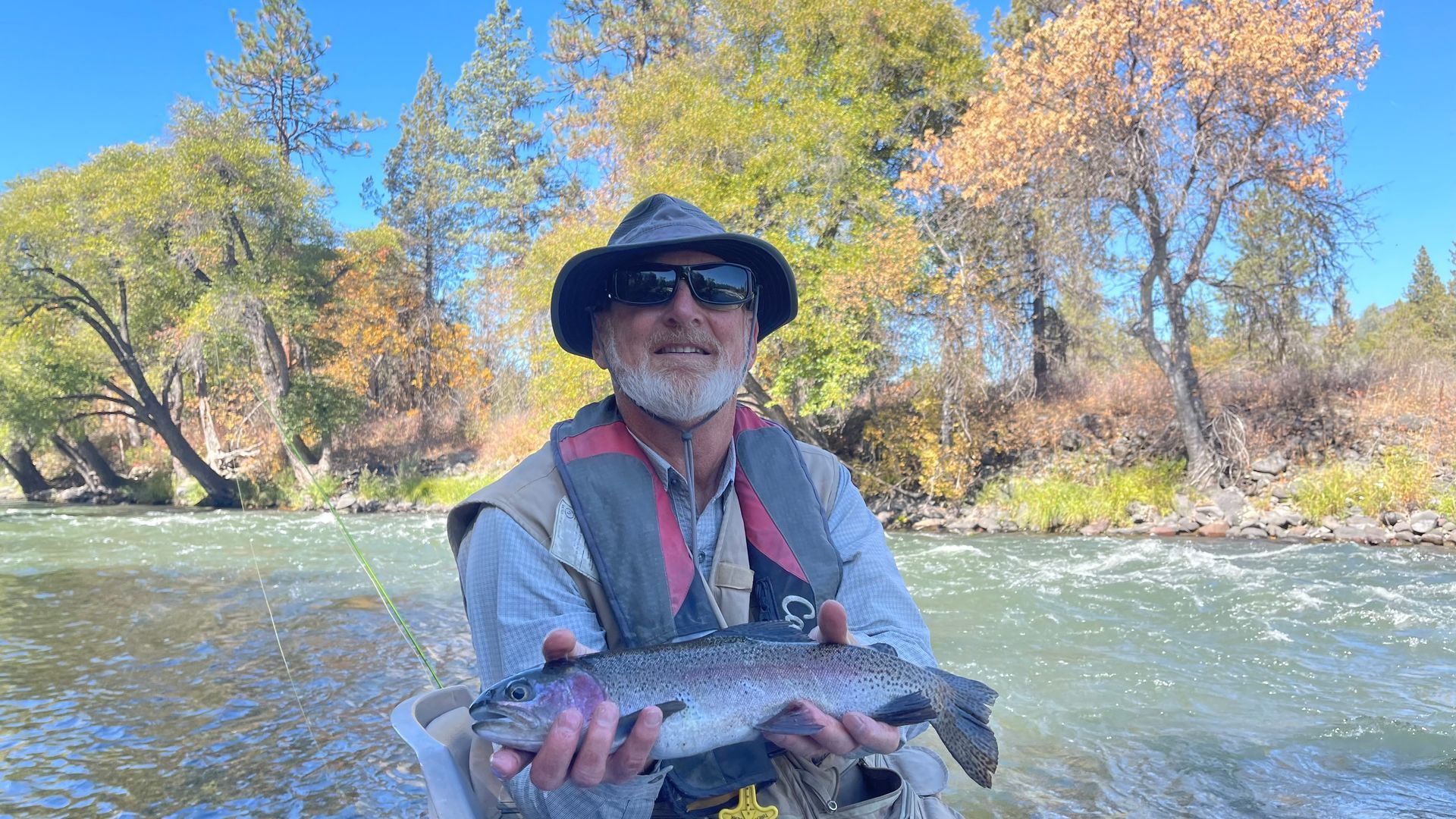 A man in a boat is holding a fish in his hands