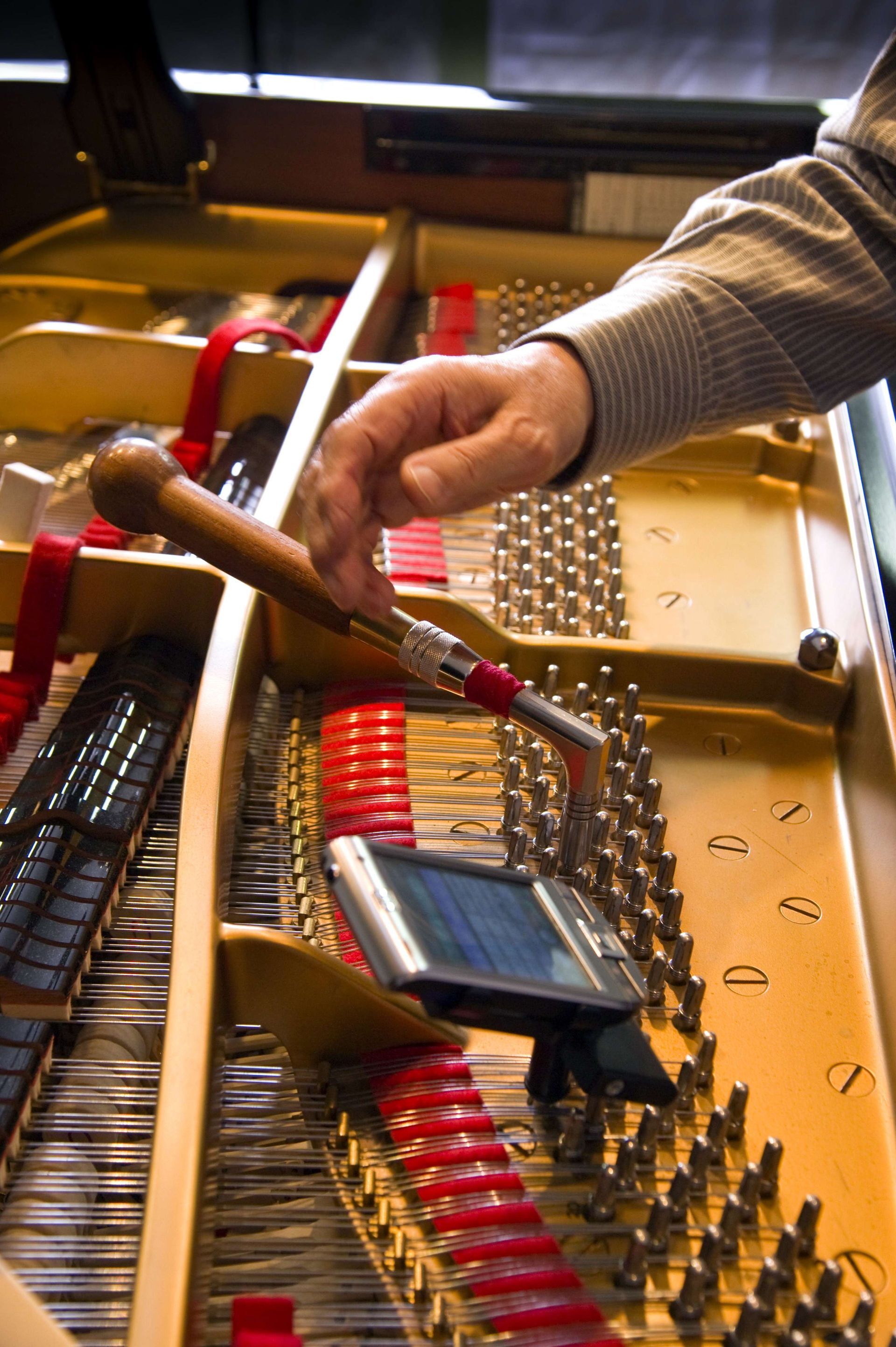 a person is working on a piano with a screwdriver