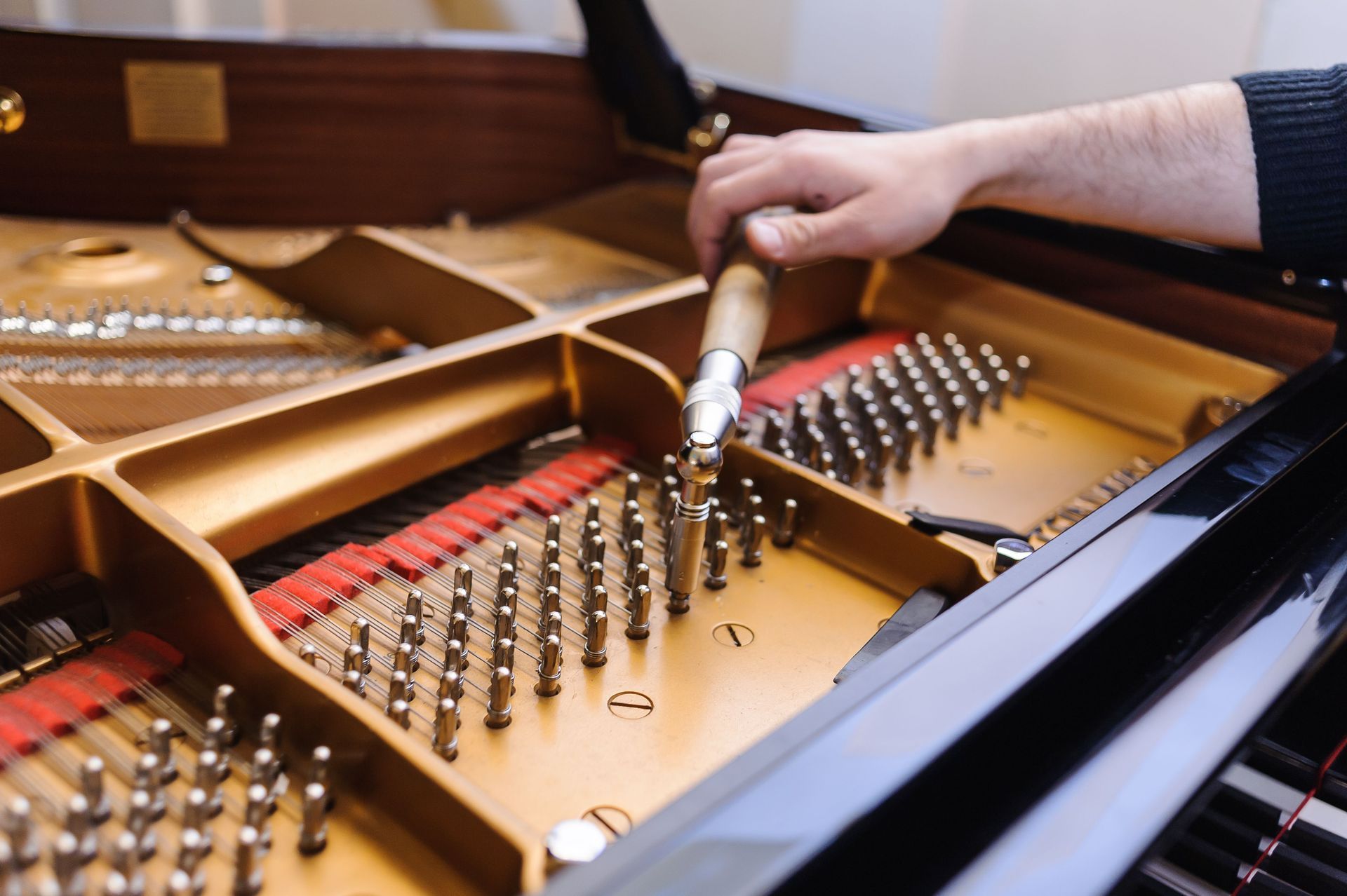 a person is working on a piano with a screwdriver