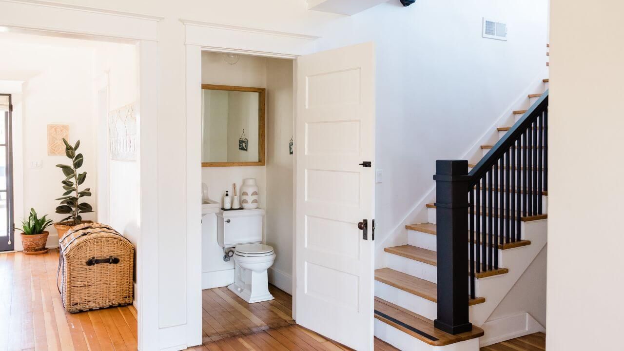 A white toilet sitting next to a wooden staircase