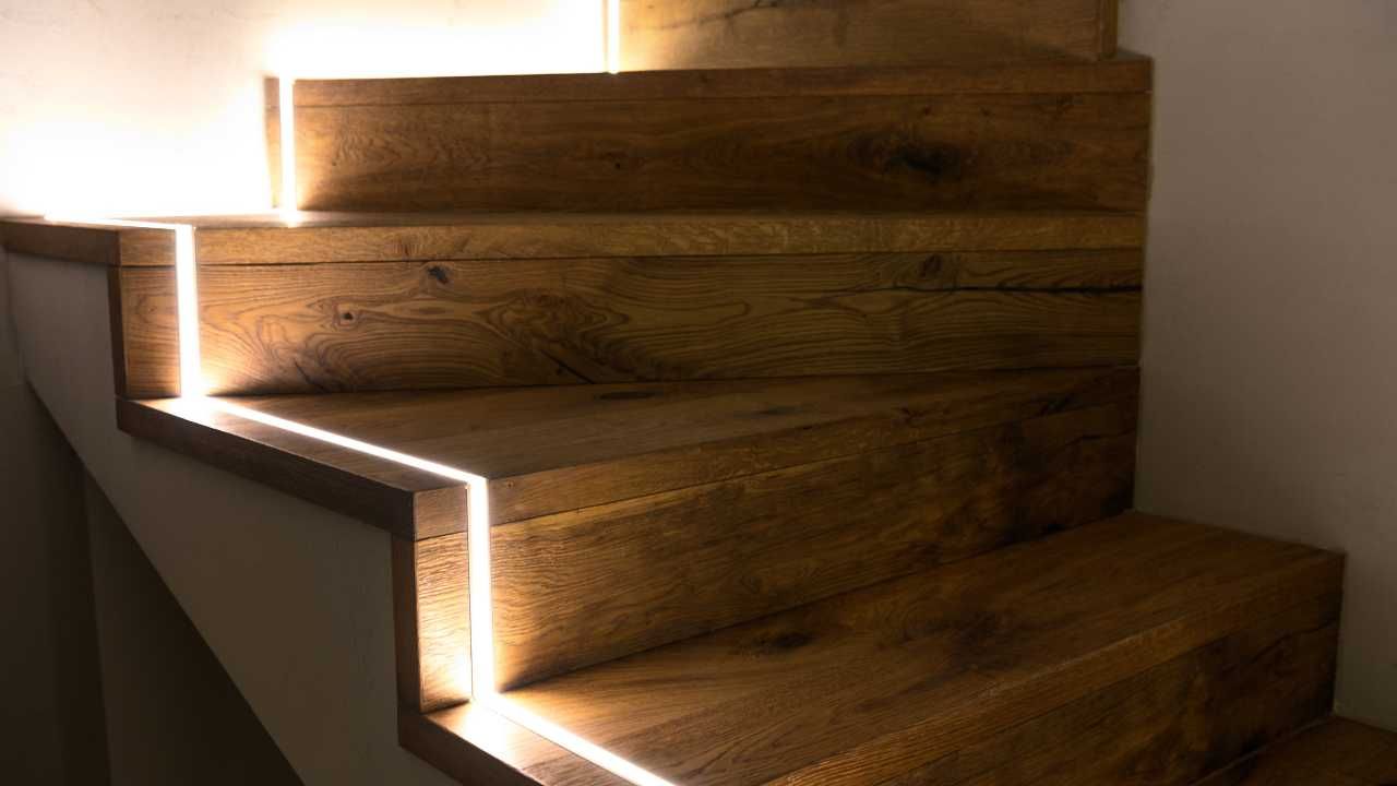 A wooden staircase with a light coming down the steps.