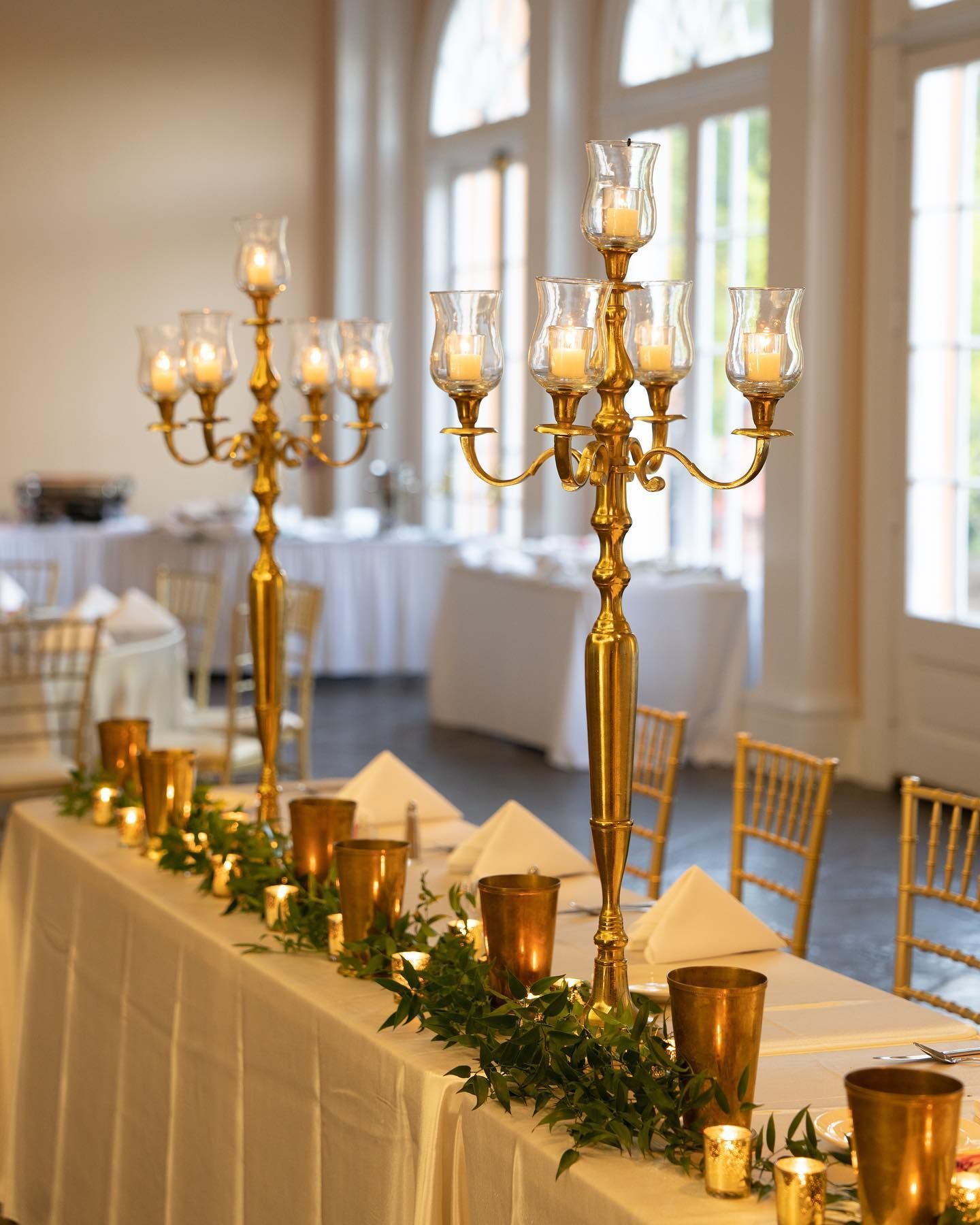 A large room filled with tables and chairs and a chandelier.