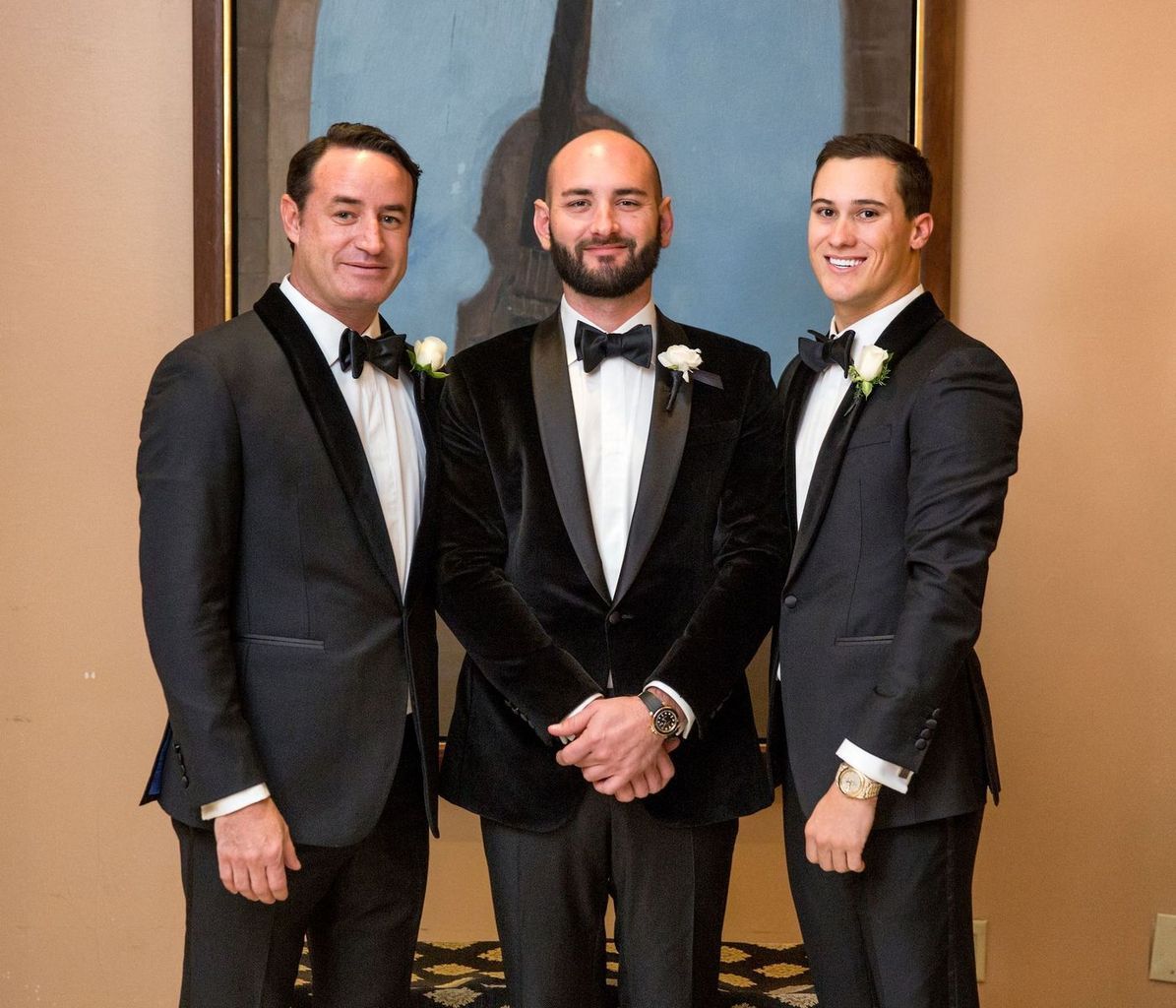 Three men in tuxedos are posing for a picture