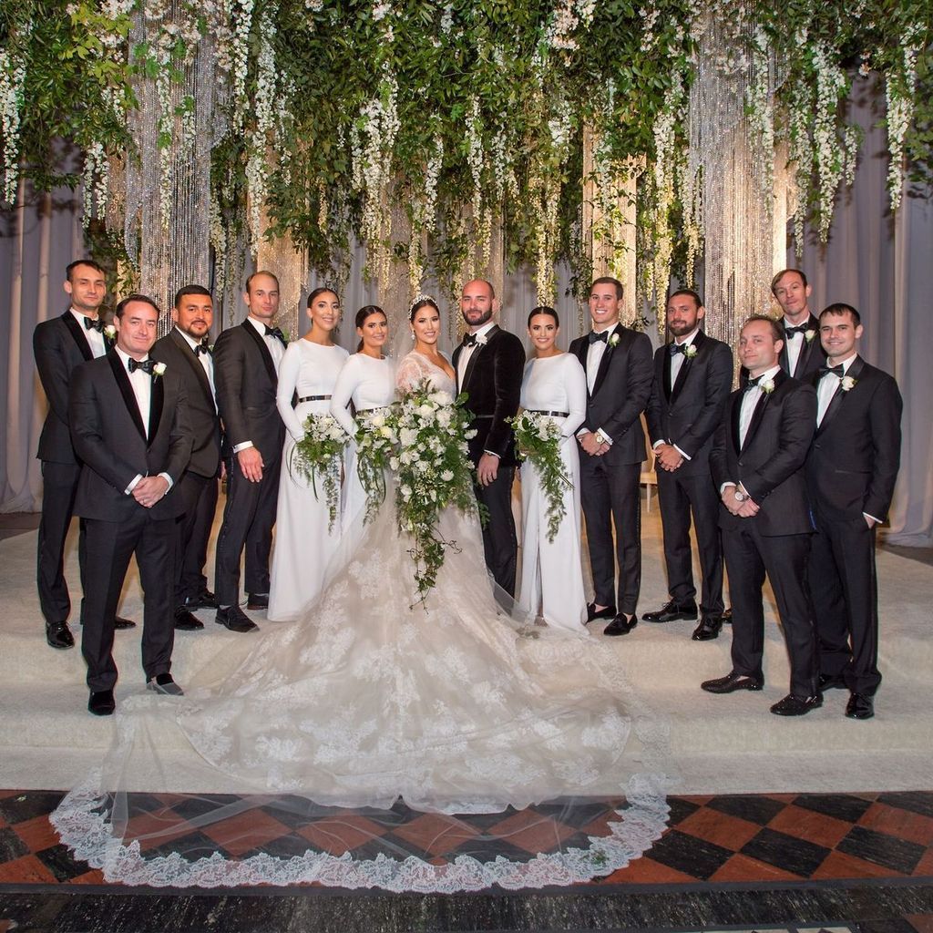 The bride and groom are posing for a picture with their wedding party