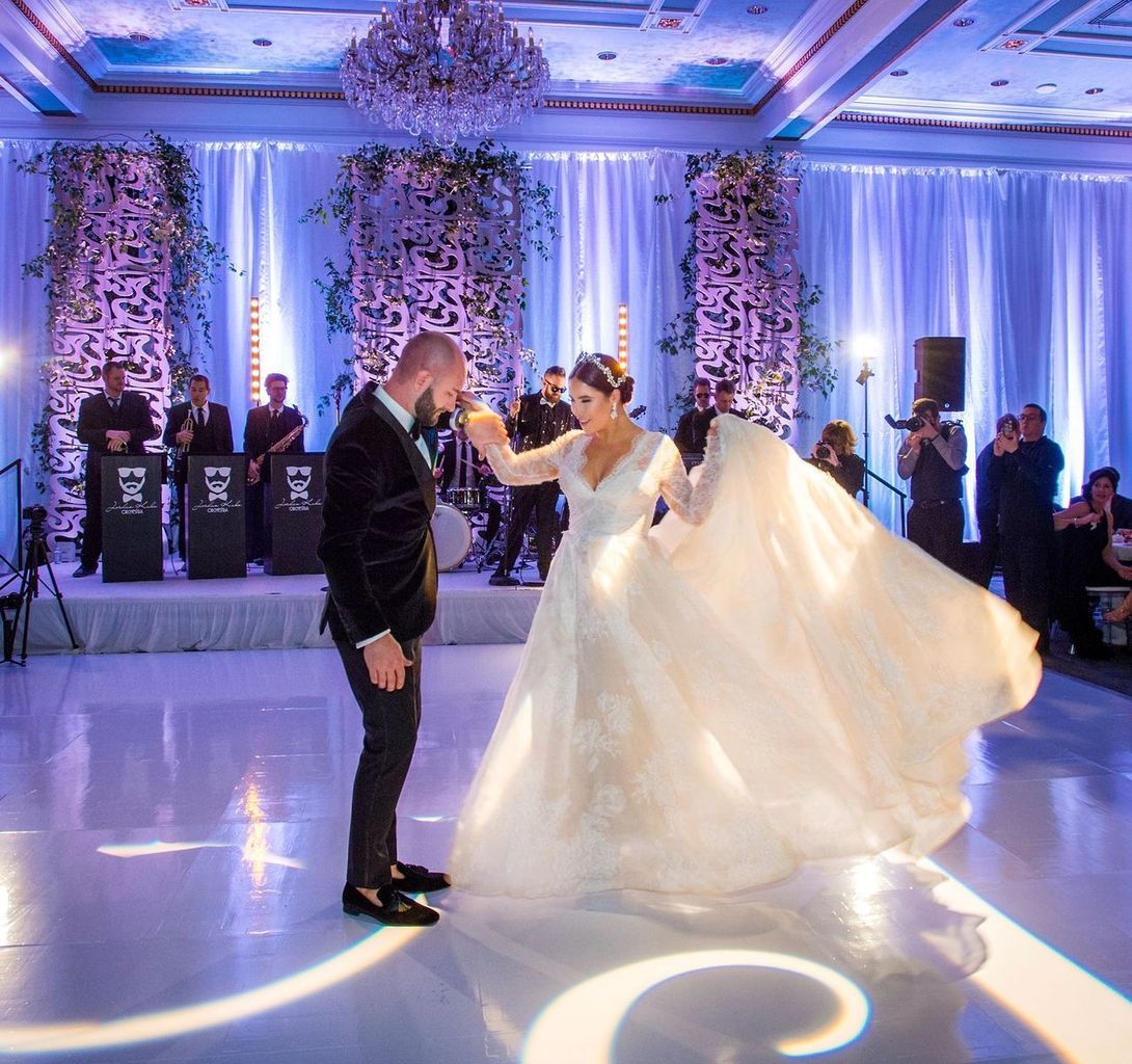 A bride and groom are dancing at their wedding reception