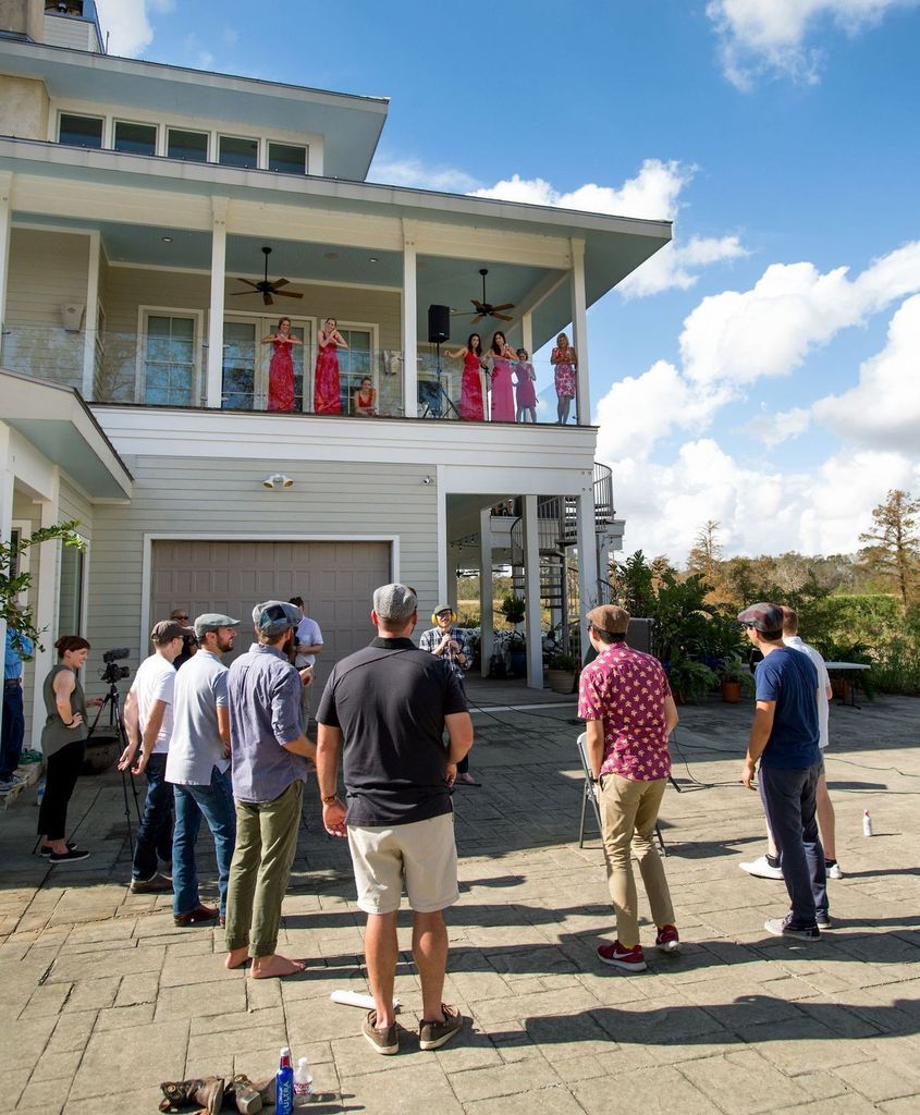 A group of people are standing in front of a large house.