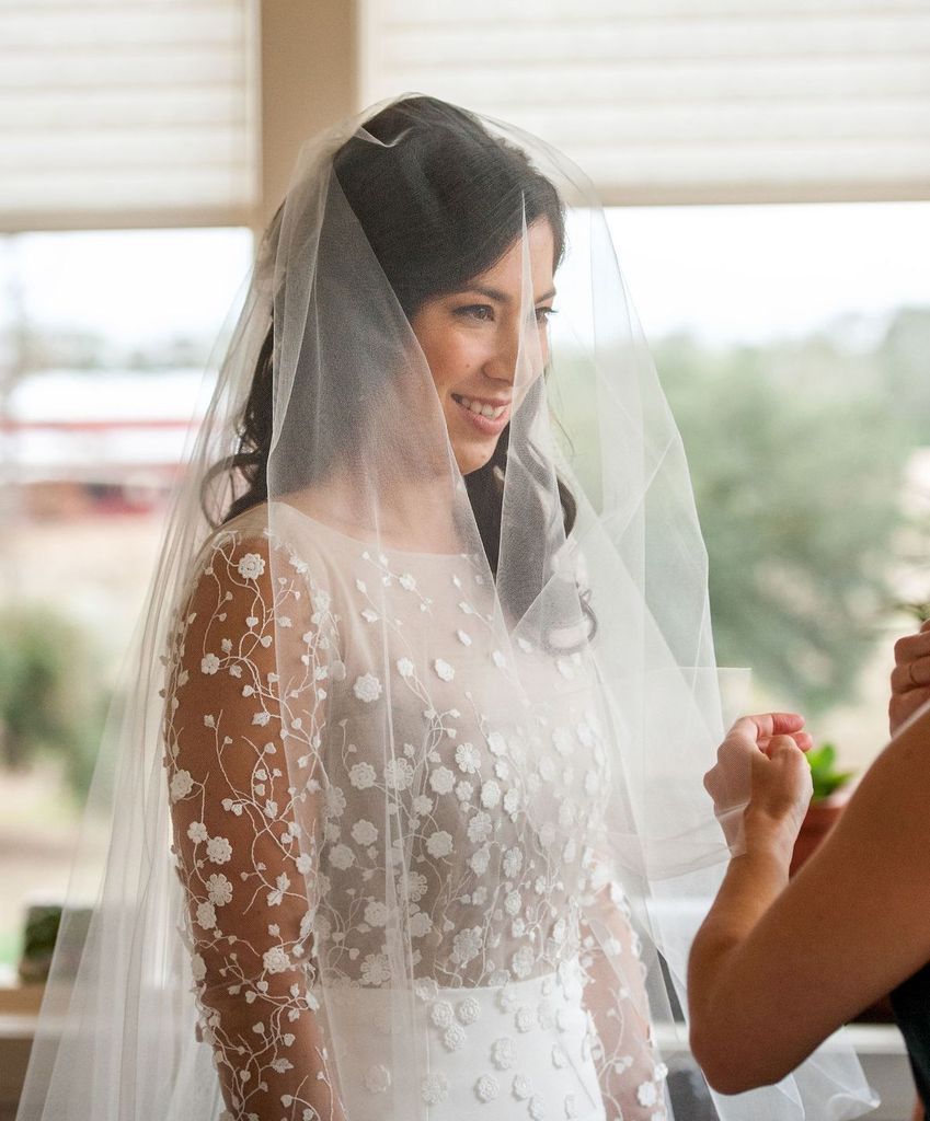 A woman in a wedding dress and veil is getting ready for her wedding.