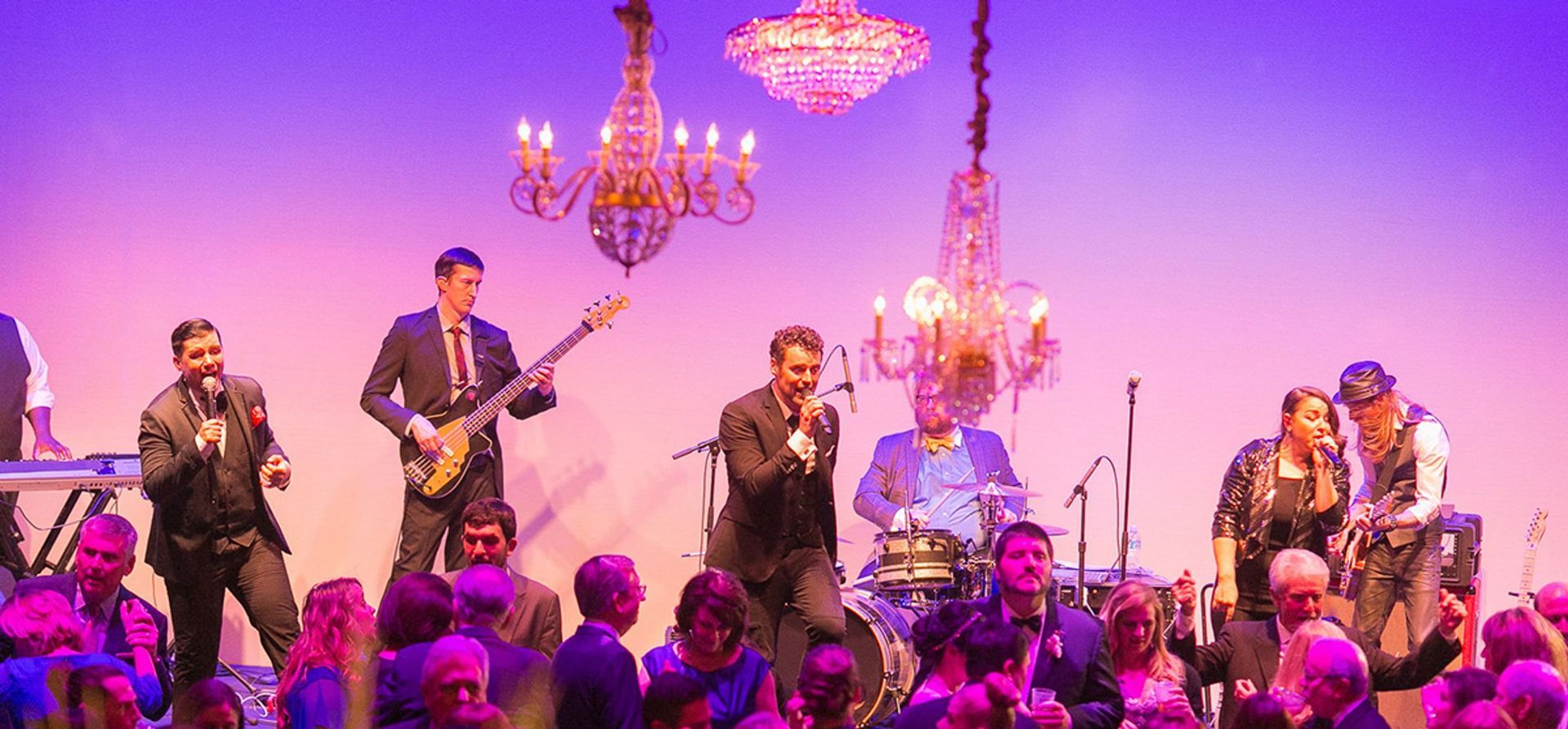 A group of people are playing instruments on a stage in front of a crowd.