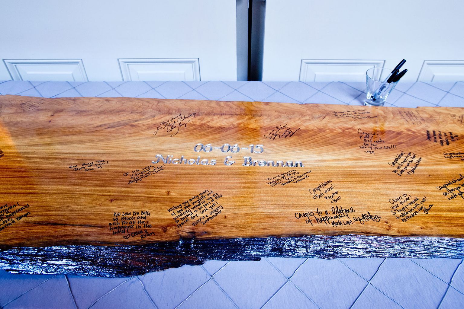 A large piece of wood with signatures on it is on a table.