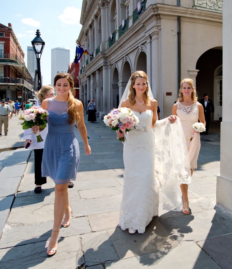 A bride and her bridesmaids are walking down the street