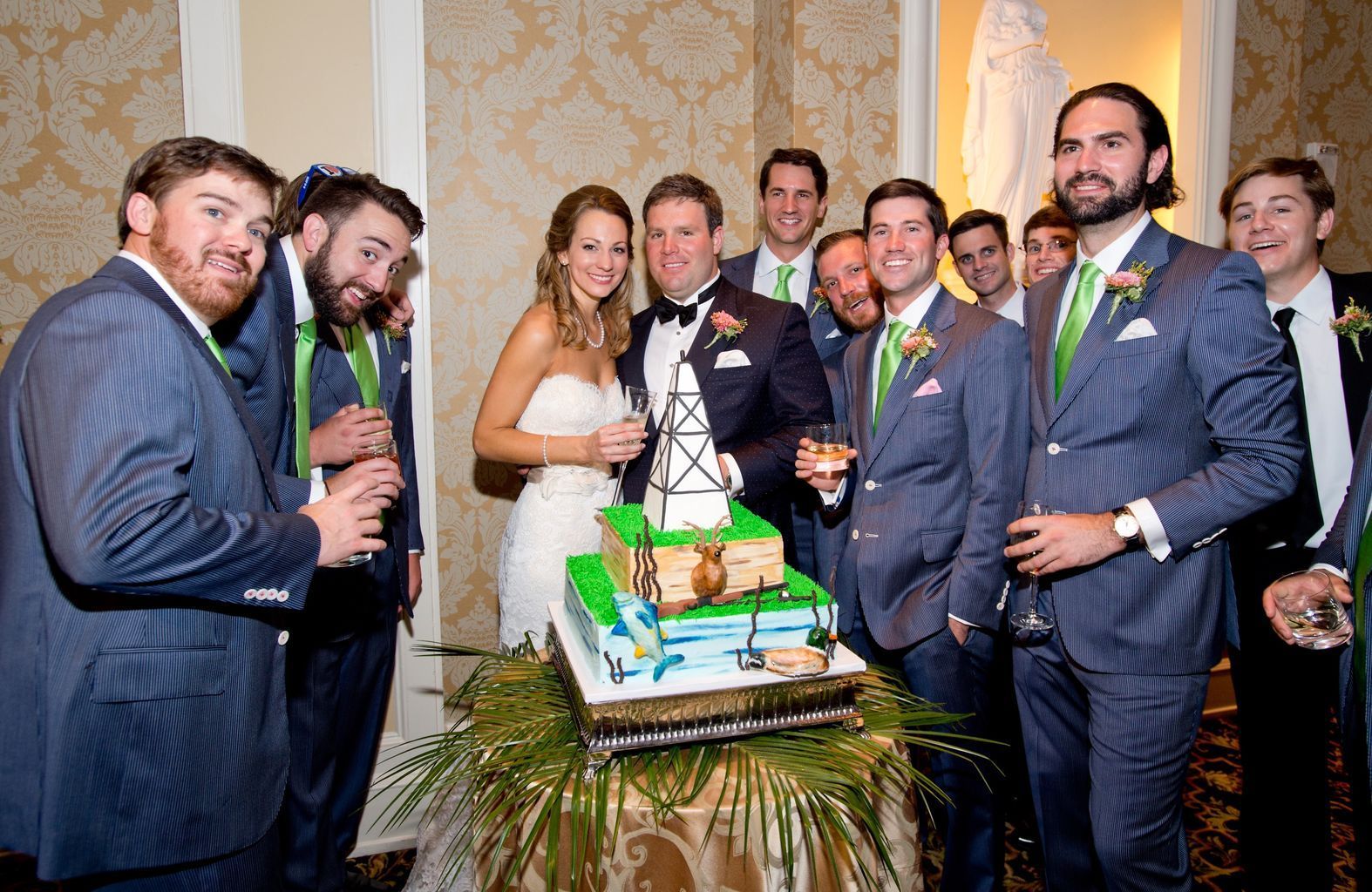 A group of people are standing around a wedding cake.