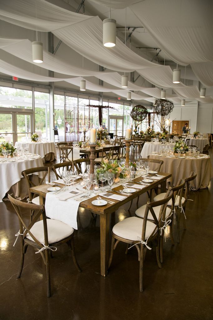 A large room with tables and chairs set up for a wedding reception.