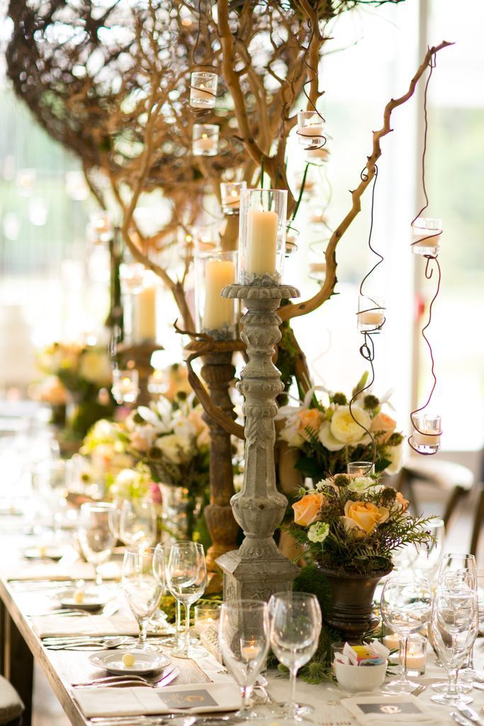 A long table with candles and flowers on it.