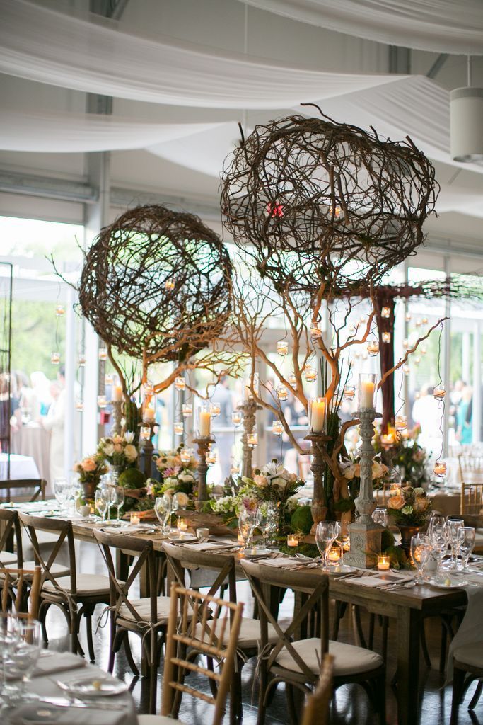A table set for a wedding reception with candles and flowers on it.