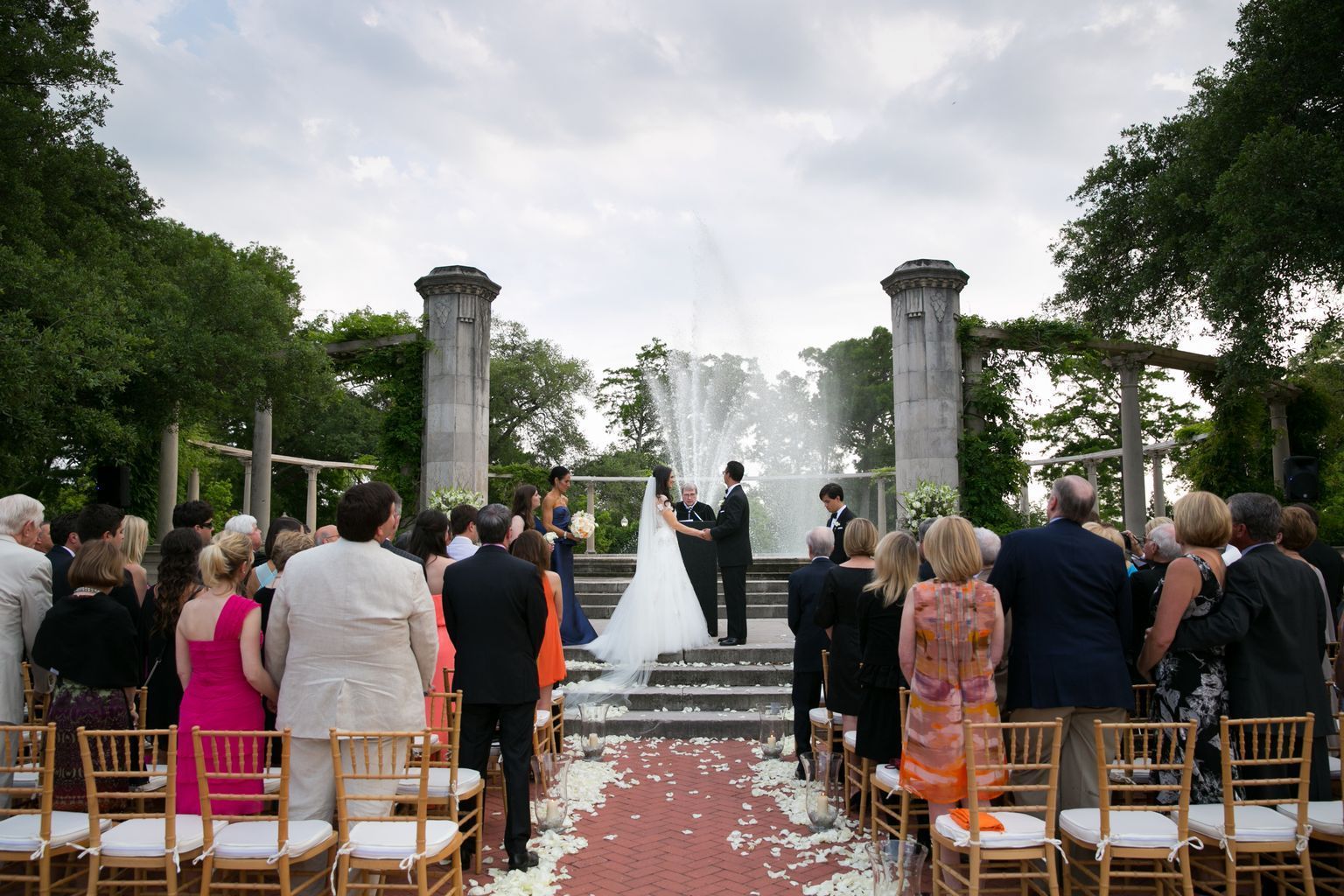 A bride and groom are getting married in front of a crowd of people.