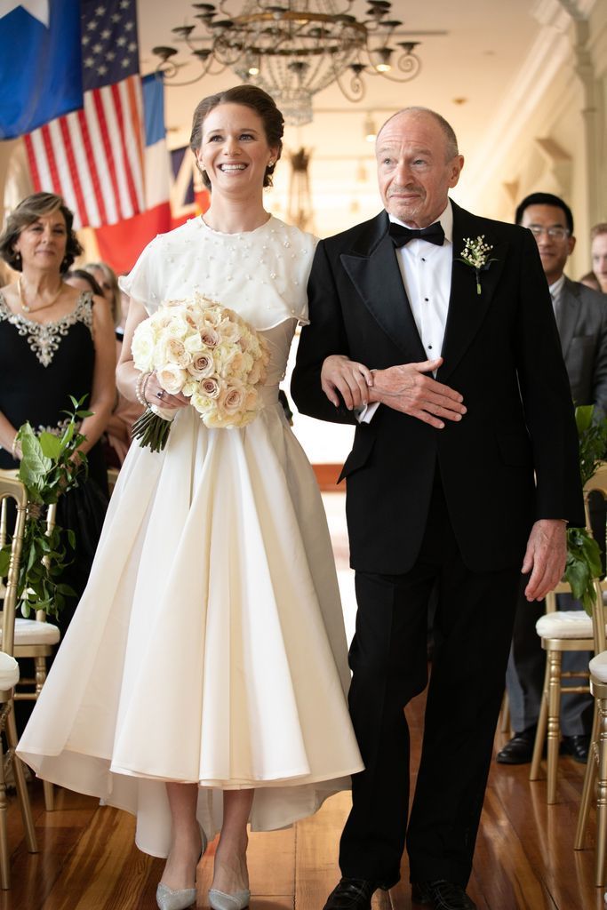 A bride and groom are walking down the aisle at their wedding.