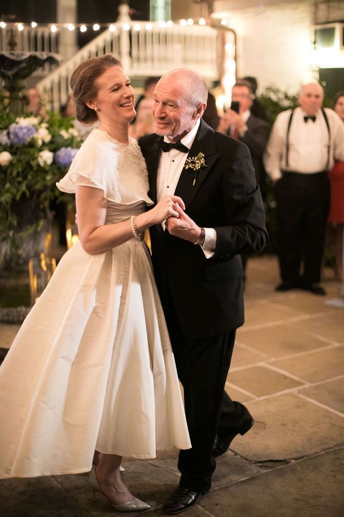 A bride and groom are dancing together at their wedding reception.