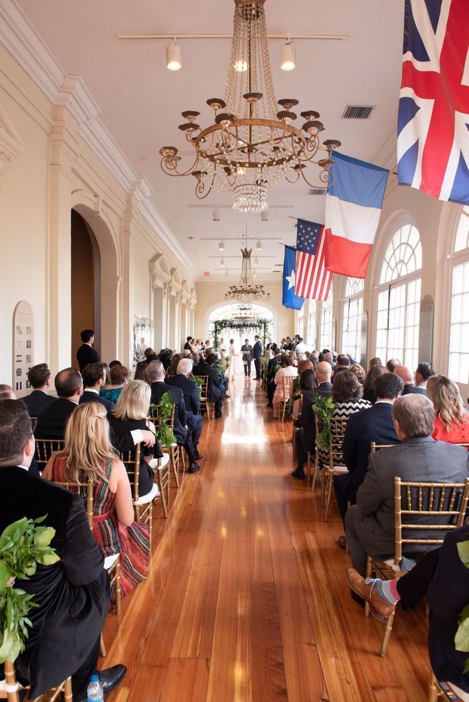 A large group of people are sitting in chairs watching a wedding ceremony.
