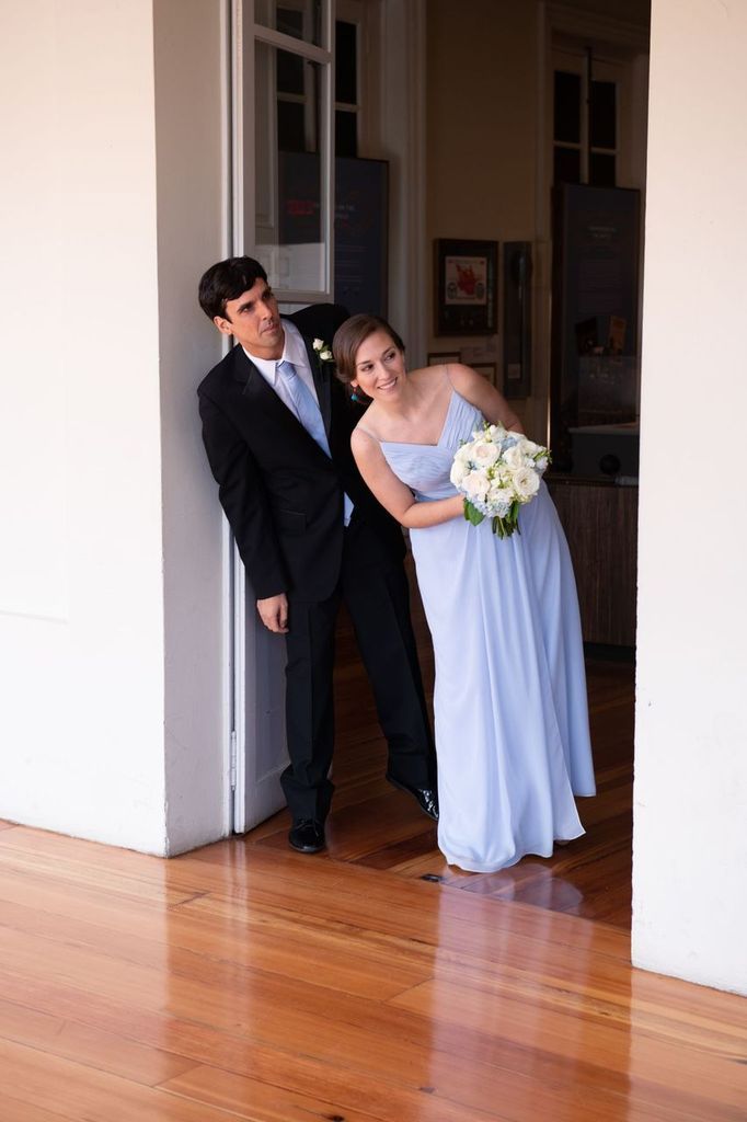 A bride and groom standing next to each other in a hallway