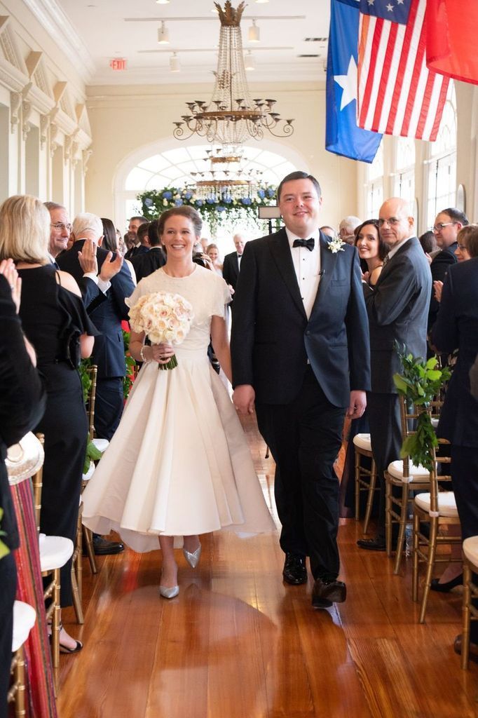 A bride and groom are walking down the aisle at their wedding.