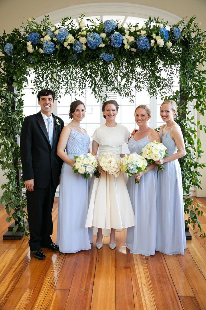The bride and groom are posing for a picture with their bridesmaids.