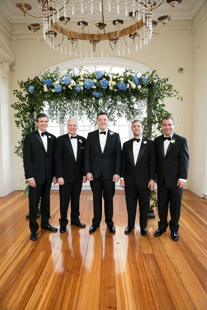 A group of men in tuxedos standing next to each other in a room.