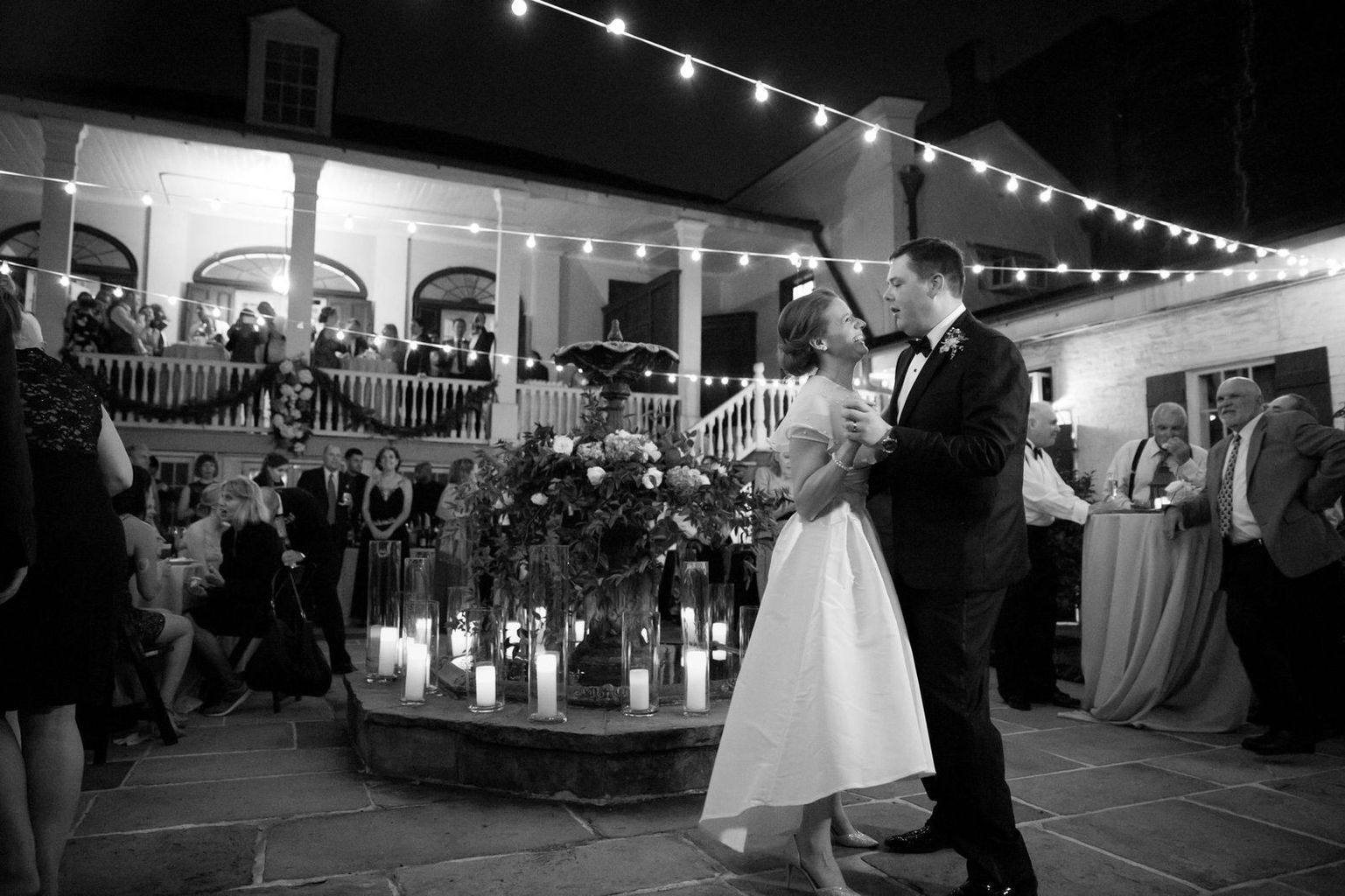 A black and white photo of a bride and groom dancing at their wedding reception.