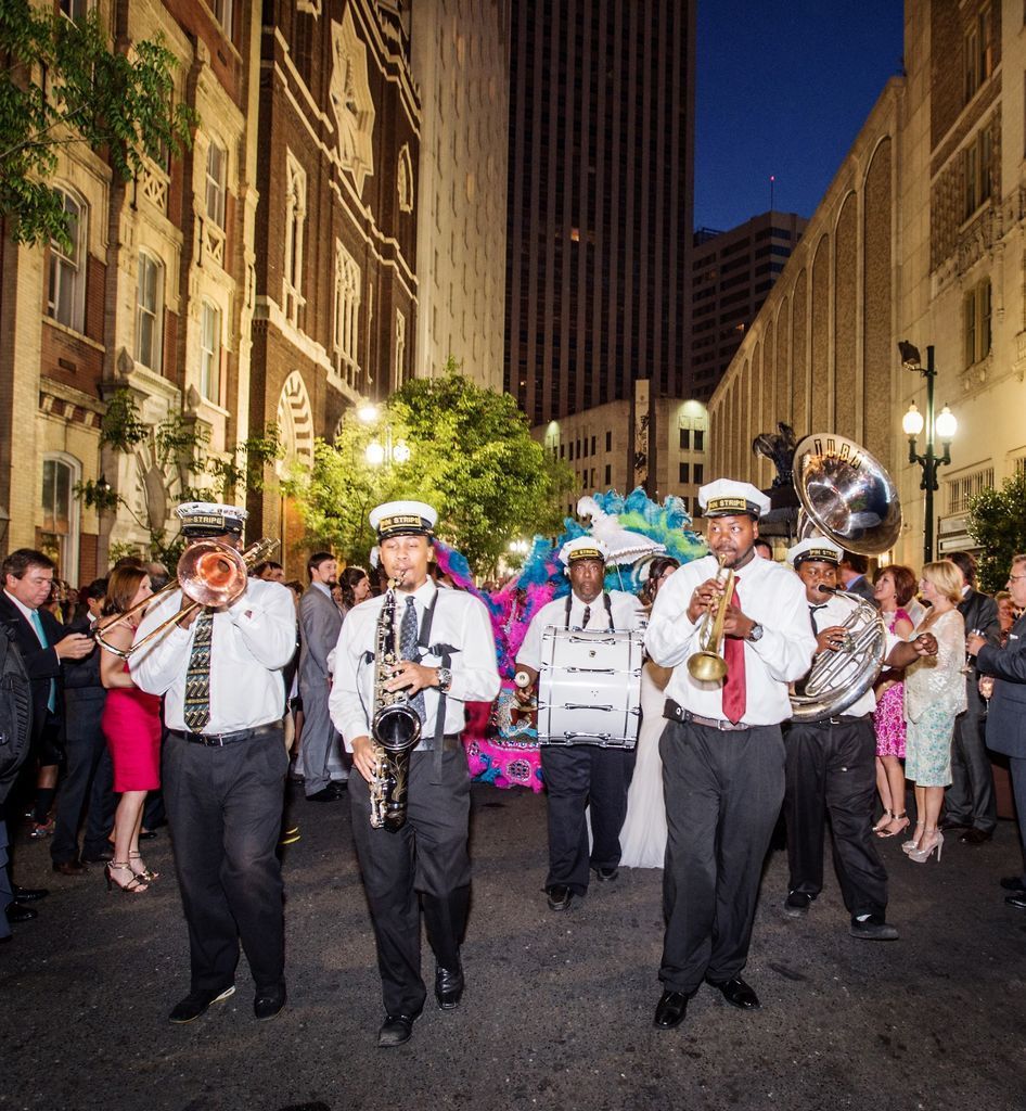 A band is marching down a city street at night