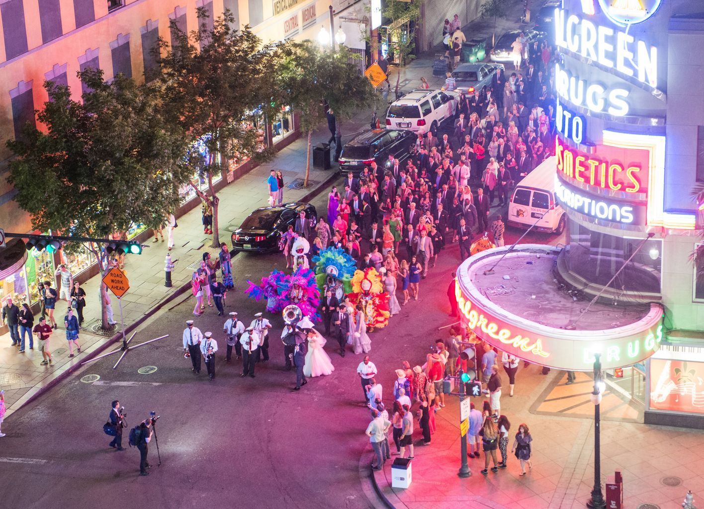 An aerial view of a parade in a city at night.