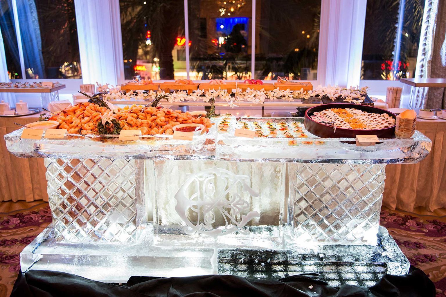 A large ice sculpture filled with food is sitting on a table.