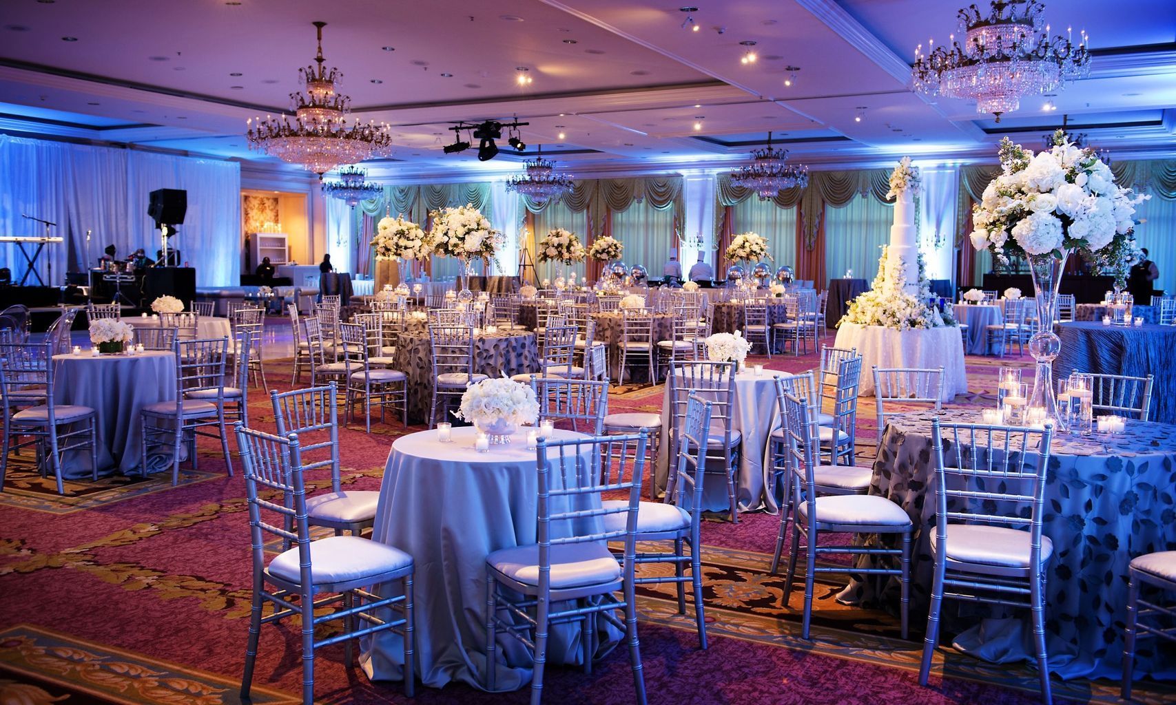 A large room filled with tables and chairs and a chandelier.